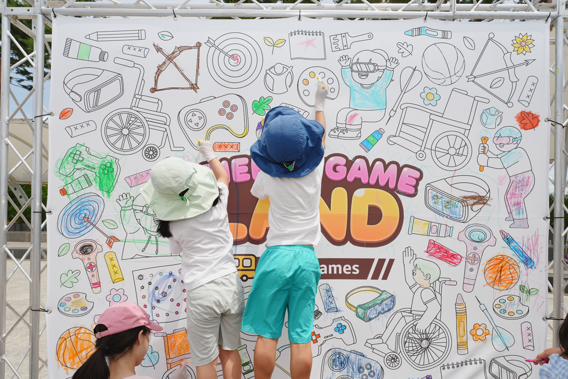 아이들이 찾아가는 프렌즈게임 랜드 컬러링월에서 그림을 그리고 있음